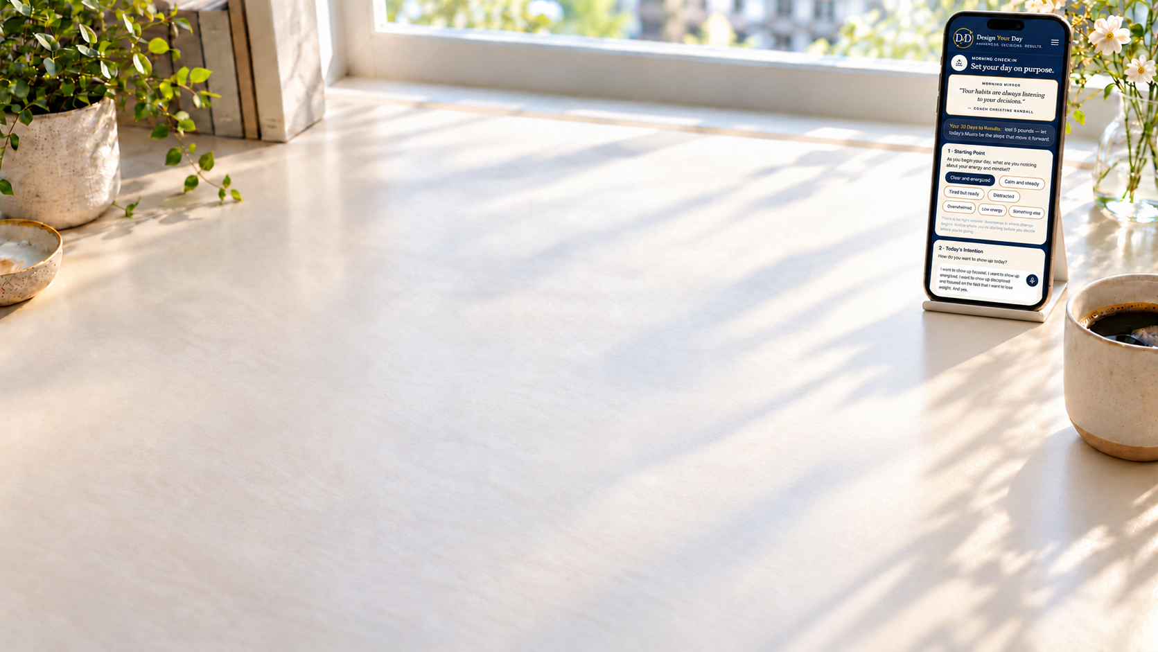 A sunlit desk with a phone showing the Design Your Day morning check-in.